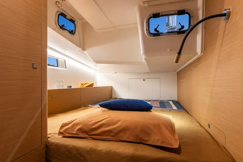  Yacht Photos Pics Interior cabin of 2026 Jeanneau Sun Odyssey 455 yacht, featuring cozy bedding and modern design.