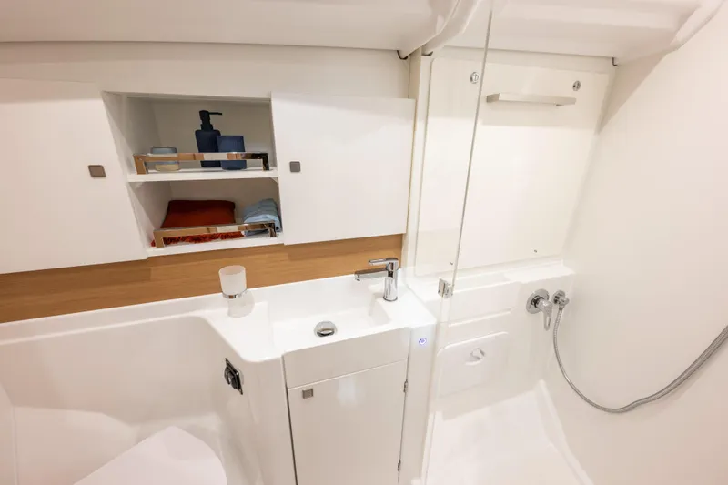  Yacht Photos Pics Modern bathroom in 2026 Jeanneau Sun Odyssey 455 yacht, featuring sleek design and storage.