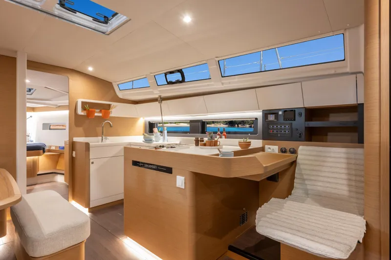 Yacht Photos Pics Interior of 2026 Jeanneau Sun Odyssey 455 yacht, featuring modern kitchen and seating area.