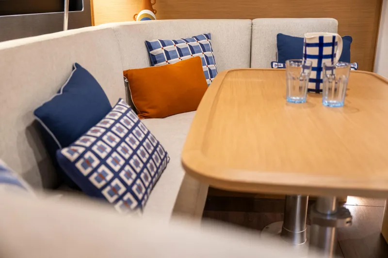  Yacht Photos Pics Interior of 2026 Jeanneau Sun Odyssey 455 with cozy seating and decorative pillows.