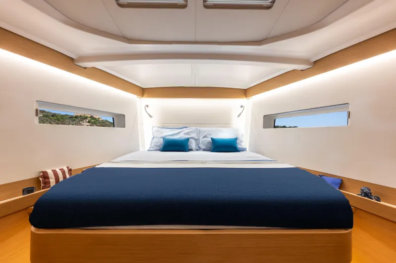 Yacht Photos Pics Luxurious cabin interior of 2026 Jeanneau Sun Odyssey 455 yacht, featuring elegant bedding and modern design.