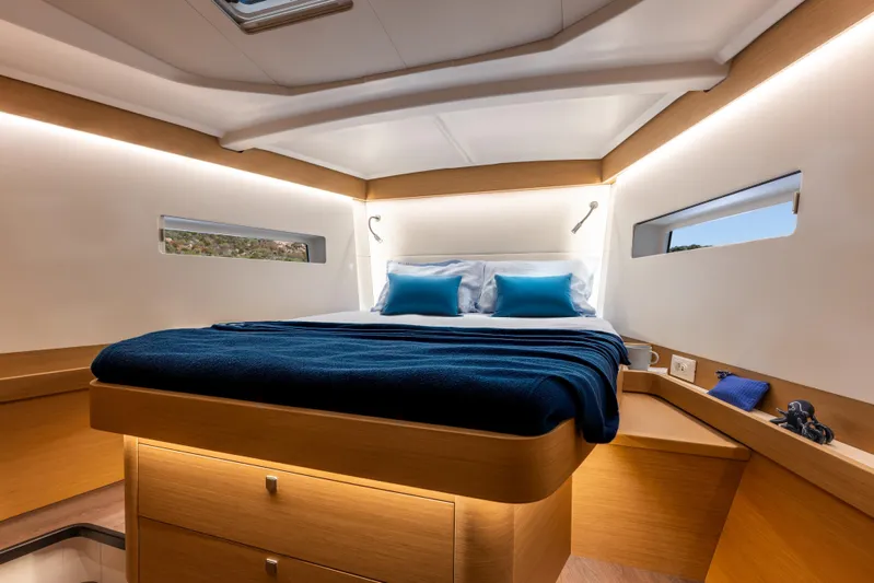  Yacht Photos Pics Luxurious cabin interior of 2026 Jeanneau Sun Odyssey 455 yacht, featuring modern design and cozy bedding.