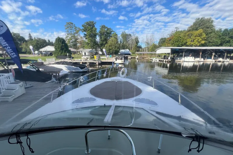  Yacht Photos Pics 2008 Cruisers Yachts 330 Express docked at a scenic marina under a blue sky.