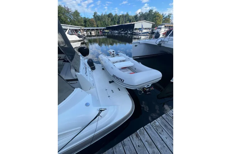  Yacht Photos Pics 2008 Cruisers Yachts 330 Express docked with inflatable boat, serene marina setting.