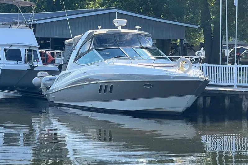  Yacht Photos Pics 2008 Cruisers Yachts 330 Express docked at marina, reflecting on calm water.