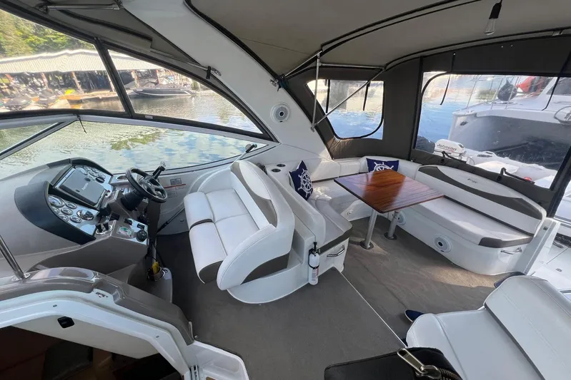  Yacht Photos Pics 2008 Cruisers Yachts 330 Express interior with helm, seating, and table on water.