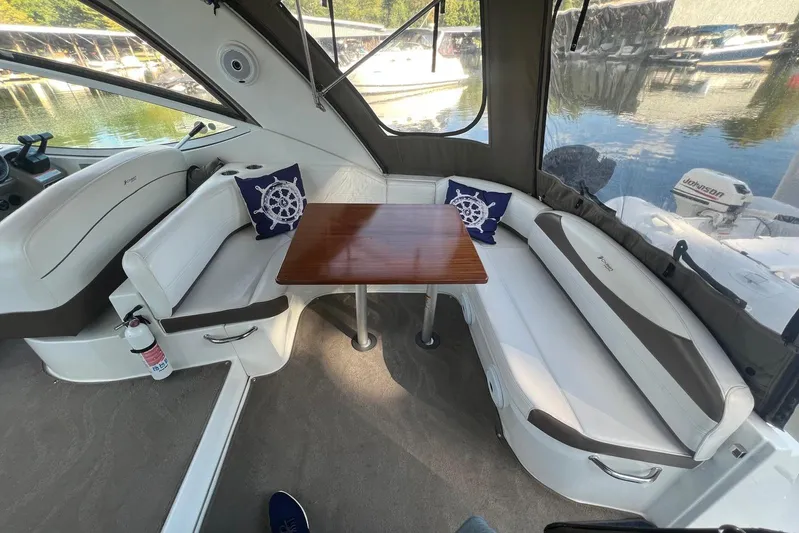  Yacht Photos Pics 2008 Cruisers Yachts 330 Express interior with seating, table, and nautical-themed cushions.