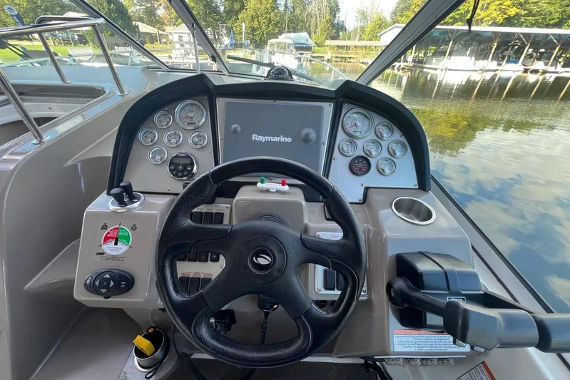  Yacht Photos Pics 2008 Cruisers Yachts 330 Express helm with steering wheel and navigation controls.