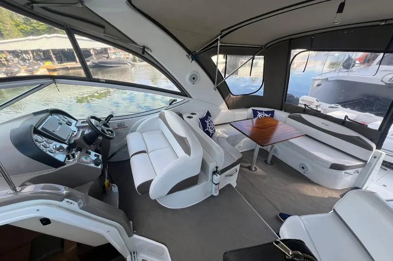  Yacht Photos Pics 2008 Cruisers Yachts 330 Express interior with helm, seating, and table on a sunny day.