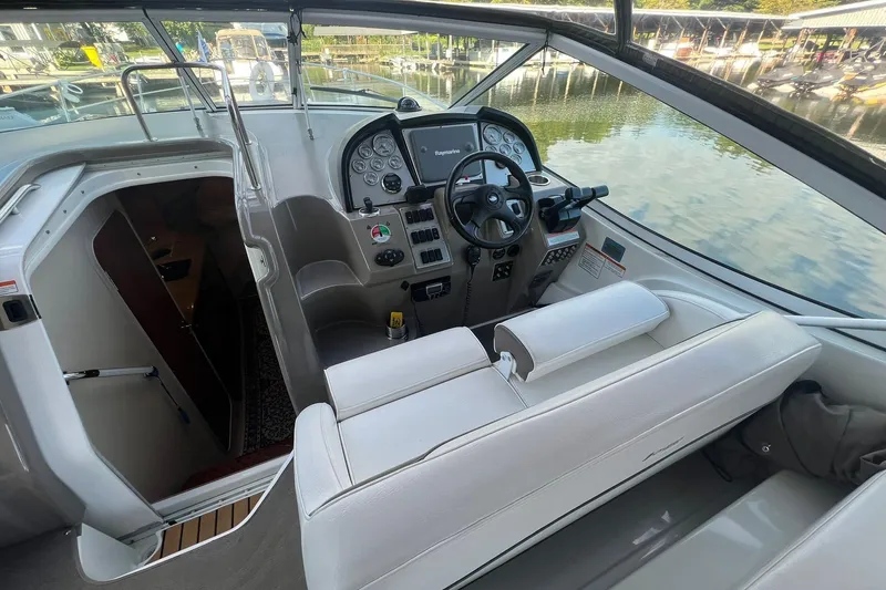  Yacht Photos Pics 2008 Cruisers Yachts 330 Express cockpit with steering wheel and control panel, docked by water.