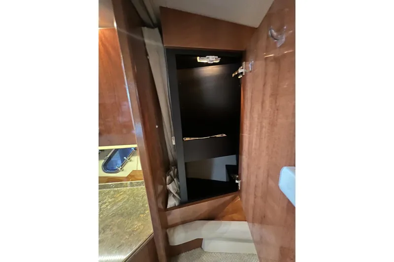  Yacht Photos Pics 2008 Cruisers Yachts 330 Express interior with open wooden cabinet and visible porthole.