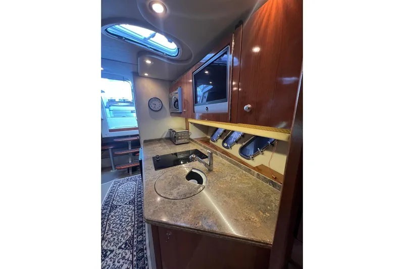  Yacht Photos Pics 2008 Cruisers Yachts 330 Express interior with kitchenette, sink, and wooden cabinetry.