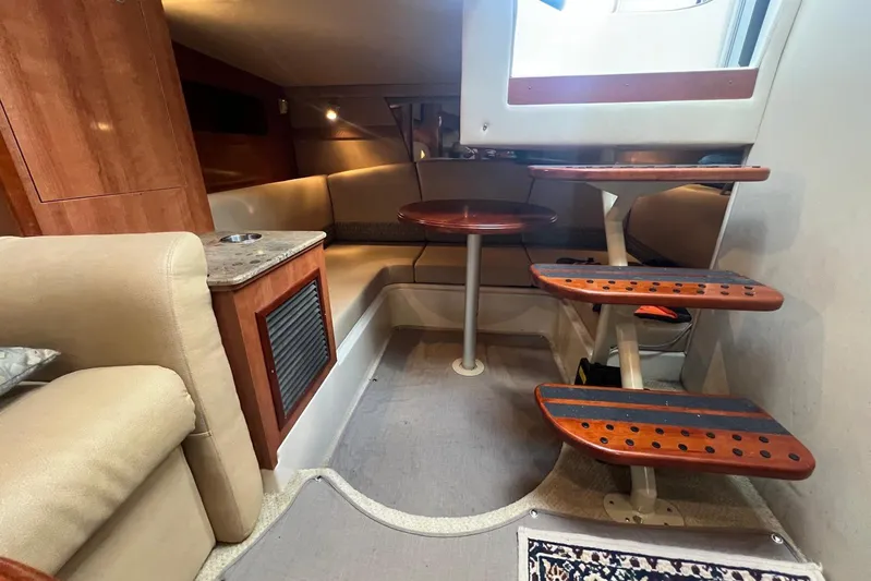  Yacht Photos Pics 2008 Cruisers Yachts 330 Express interior with cozy seating and wooden steps.