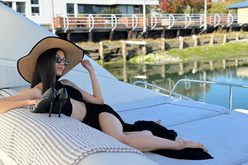  Yacht Photos Pics Woman relaxing on a 1998 Sunseeker Predator 63 yacht, wearing a sun hat and sunglasses.