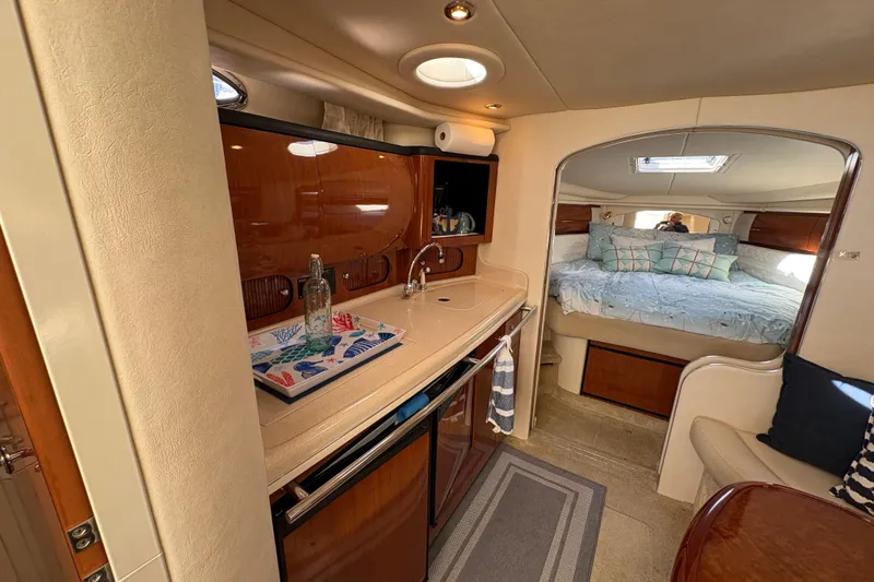 Devocean Yacht Photos Pics Interior of 2003 Sea Ray 360 Sundancer yacht with kitchenette and cozy bedroom.