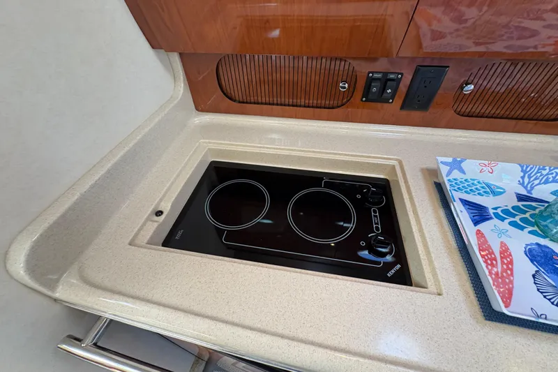 Devocean Yacht Photos Pics 2003 Sea Ray 360 Sundancer kitchen with electric stove and colorful fish-themed decor.