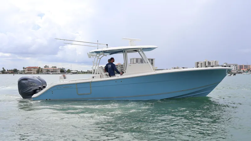 Big Sea Yacht Photos Pics 2020 Cobia 350 Center Console boat cruising on water with cityscape background.