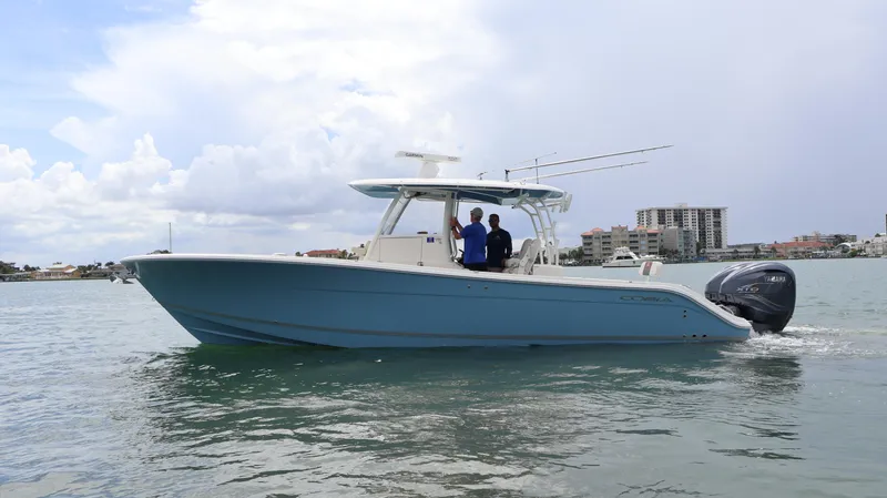 Big Sea Yacht Photos Pics 2020 Cobia 350 Center Console boat cruising on water, with cityscape background.