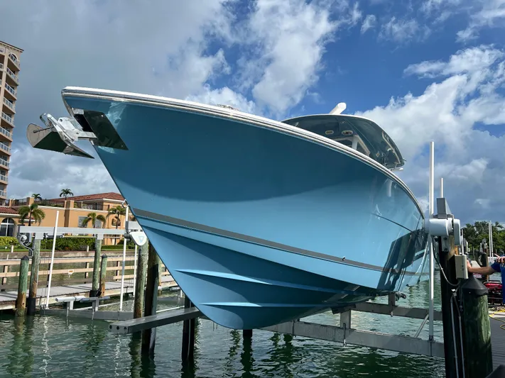Big Sea Yacht Photos Pics 2020 Cobia 350 Center Console boat on lift, blue hull, sunny day.