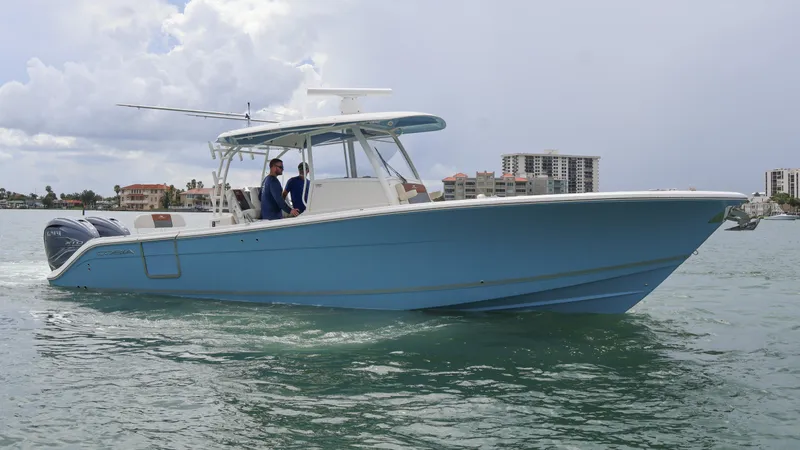 Big Sea Yacht Photos Pics 2020 Cobia 350 Center Console boat cruising on water, with cityscape in background.