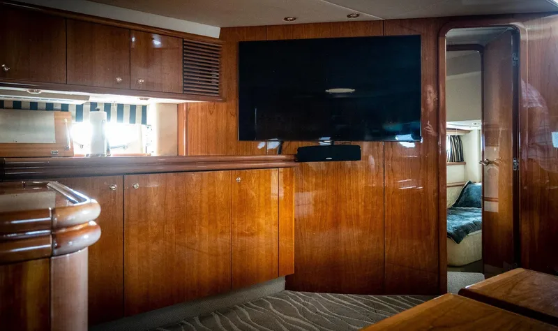  Yacht Photos Pics Luxurious interior of a 1998 Sunseeker Predator 63 yacht with wooden cabinetry and a flat-screen TV.