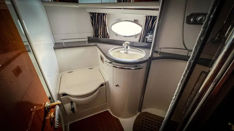  Yacht Photos Pics 1998 Sunseeker Predator 63 yacht bathroom with sink, toilet, and porthole window.