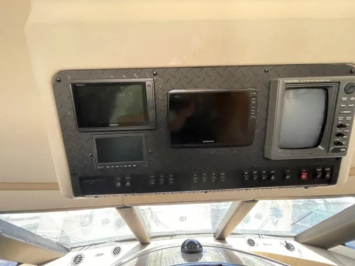 Relentless Yacht Photos Pics Control panel of a 1998 Carver 530 Voyager Pilothouse with multiple screens and switches.