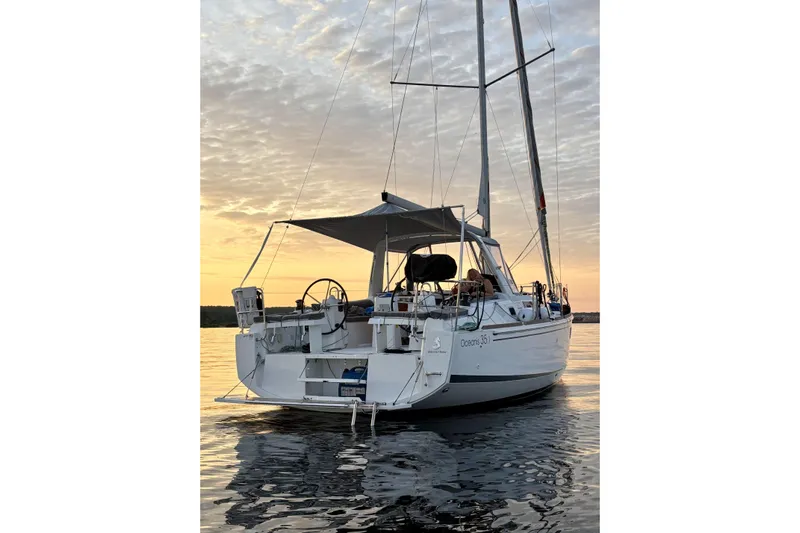  Yacht Photos Pics 2019 Beneteau Oceanis 35.1 sailboat at sunset on calm waters.