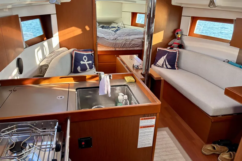  Yacht Photos Pics Interior of 2019 Beneteau Oceanis 35.1 sailboat with cozy seating and nautical decor.