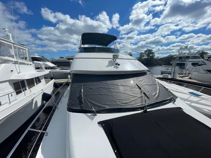 Relentless Yacht Photos Pics 1998 Carver 530 Voyager Pilothouse yacht docked under a partly cloudy sky.