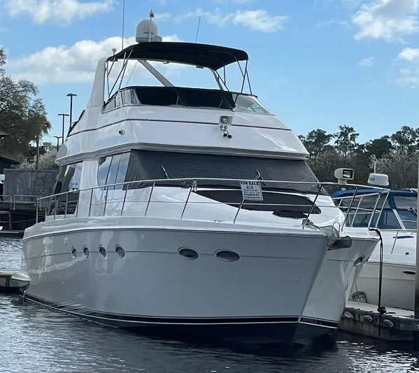 Relentless Yacht Photos Pics 1998 Carver 530 Voyager Pilothouse yacht docked at marina under blue sky.