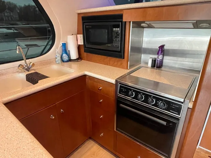 Relentless Yacht Photos Pics 1998 Carver 530 Voyager Pilothouse kitchen with stove, microwave, and sink.