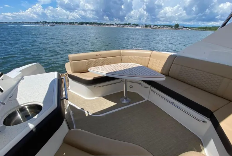 Hanamahina Yacht Photos Pics 2019 Sea Ray Sundancer 320 yacht interior with seating and table, overlooking scenic water view.