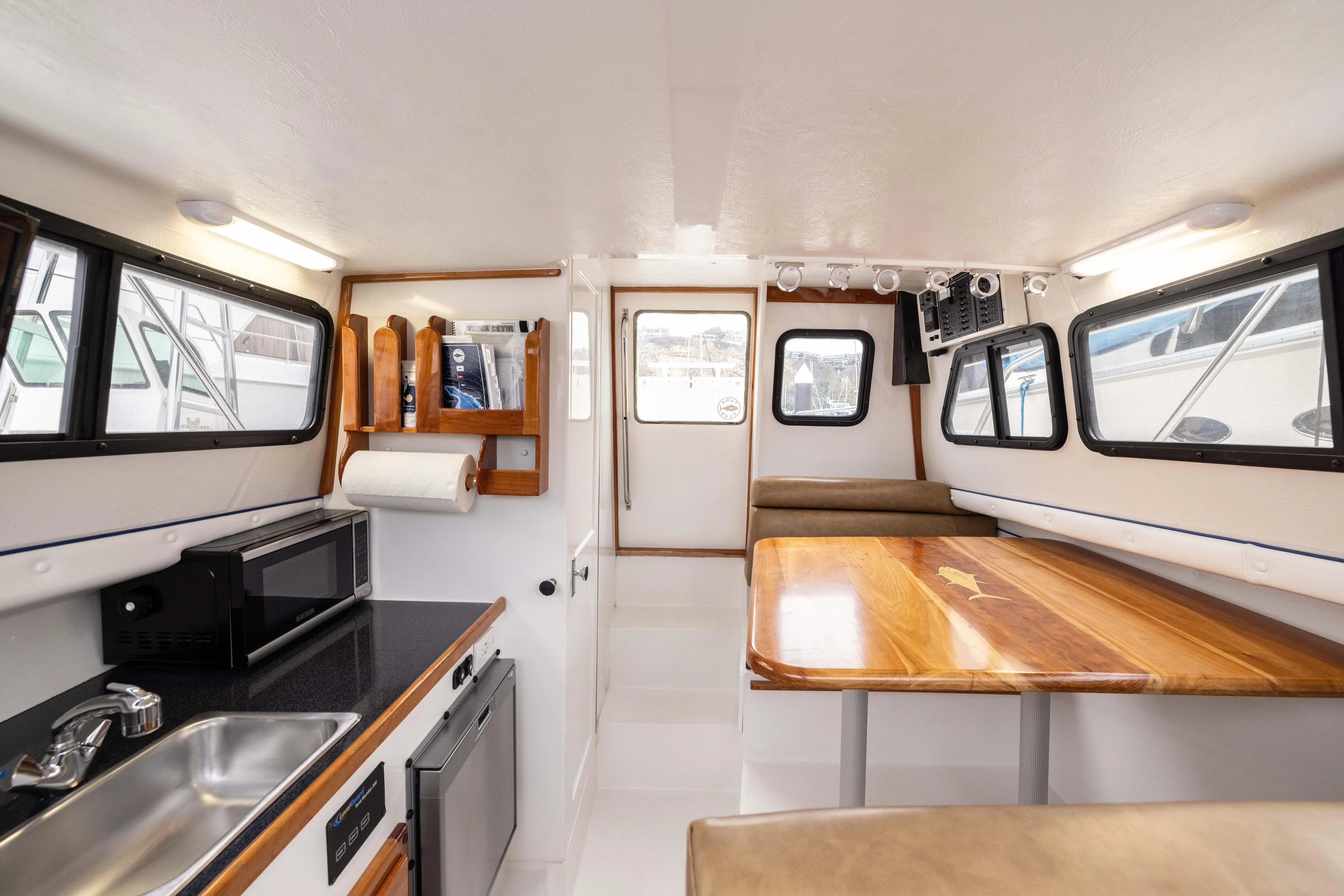 5th Kid Yacht Photos Pics Interior of 2023 Skipjack 26 Flybridge boat with kitchenette and dining area.