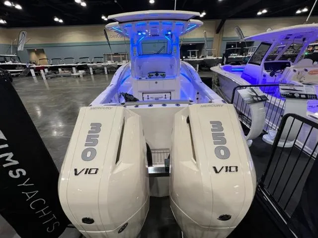  Yacht Photos Pics 2024 Scout 330 LXF boat with dual Mercury 350 V10 engines, showcased indoors.