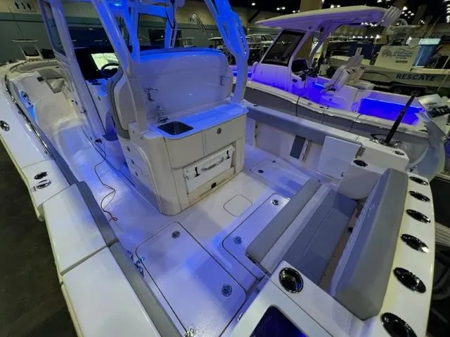  Yacht Photos Pics 2024 Scout 330 LXF boat interior with seating and storage, showcased under blue lighting.