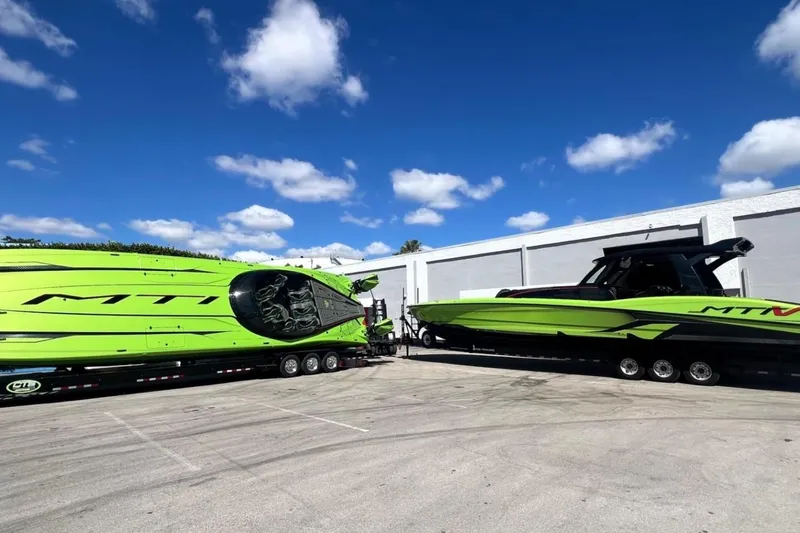  Yacht Photos Pics Bright green MTI 440X boats on trailers under a clear blue sky, 2025 model.