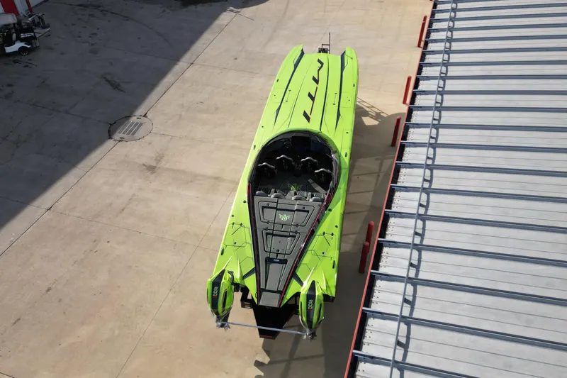  Yacht Photos Pics Aerial view of a vibrant green 2025 MTI 440X powerboat docked on concrete.