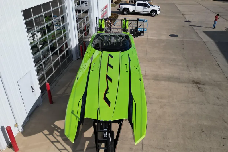  Yacht Photos Pics Bright green MTI 440X powerboat, 2025 model, parked outside a garage.