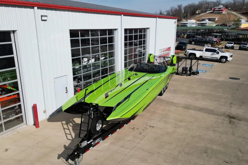  Yacht Photos Pics Bright green 2025 MTI 440X powerboat on trailer outside a garage.