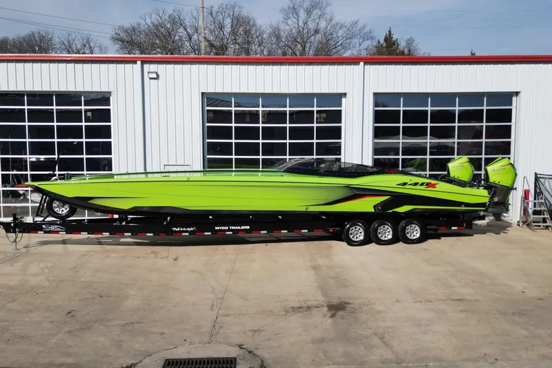  Yacht Photos Pics 2025 MTI 440X powerboat in vibrant green on a trailer outside a garage.