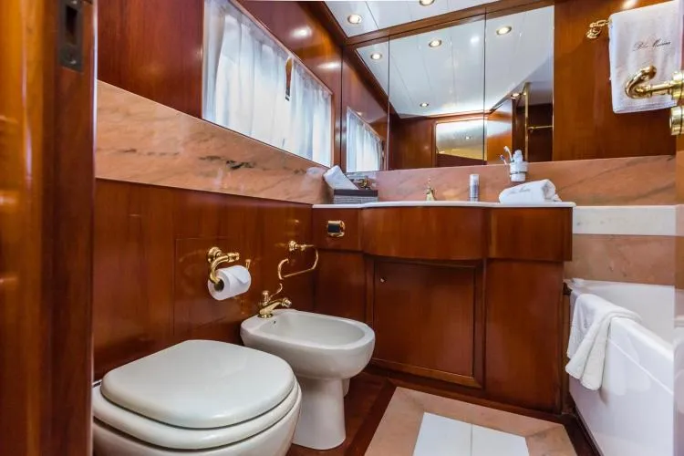  Yacht Photos Pics Luxurious wooden bathroom interior on 1999 Alalunga Navetta 30 yacht, featuring gold fixtures.