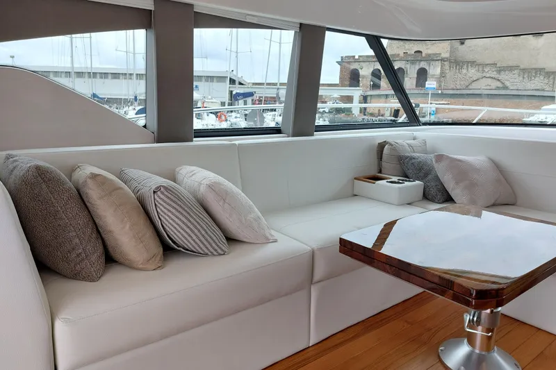 Enjoy Yacht Photos Pics Luxurious interior of 2023 Tiara Yachts C44 Coupe with plush seating and elegant table.