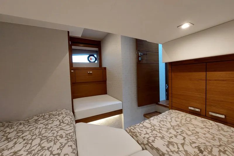 Enjoy Yacht Photos Pics 2023 Tiara Yachts C44 Coupe interior cabin with modern wood finishes and twin beds.