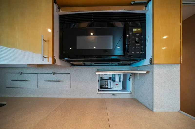 Big Boyd Yacht Photos Pics Modern kitchen appliances in 2003 Hatteras 54 Convertible yacht, featuring microwave and coffee maker.