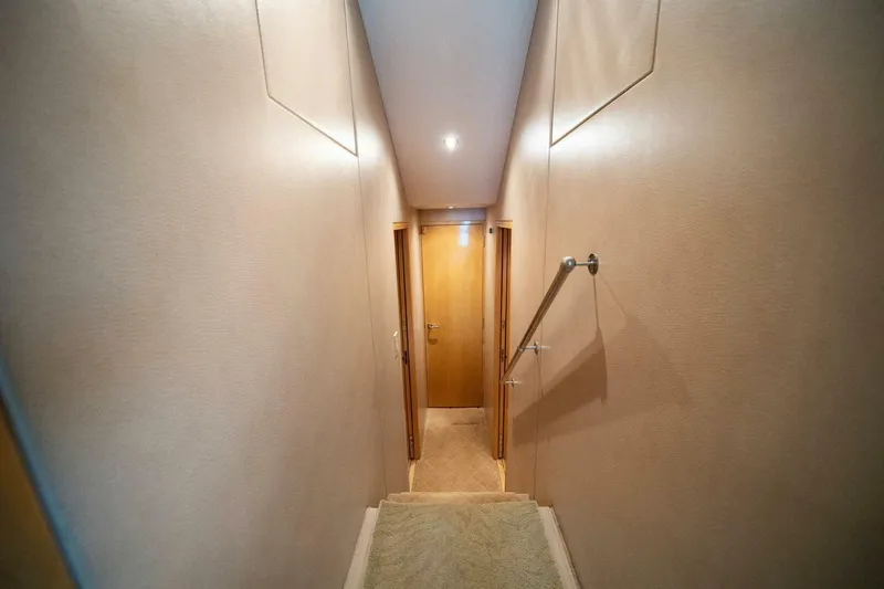 Big Boyd Yacht Photos Pics Narrow hallway inside 2003 Hatteras 54 Convertible yacht with wooden doors and handrail.