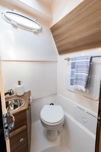  Yacht Photos Pics Compact bathroom in 2025 Solara S-310 CW boat with modern fixtures and wood accents.