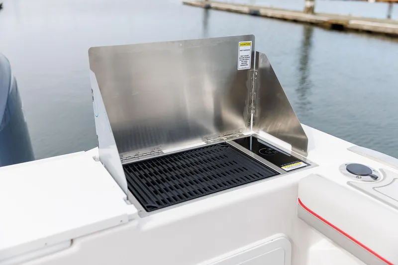  Yacht Photos Pics Solara S-310 CW 2025 boat grill with stainless steel cover by the water.