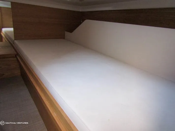  Yacht Photos Pics 2022 De Antonio Yachts D34 Xplorer cabin bed with wooden accents and white mattress.