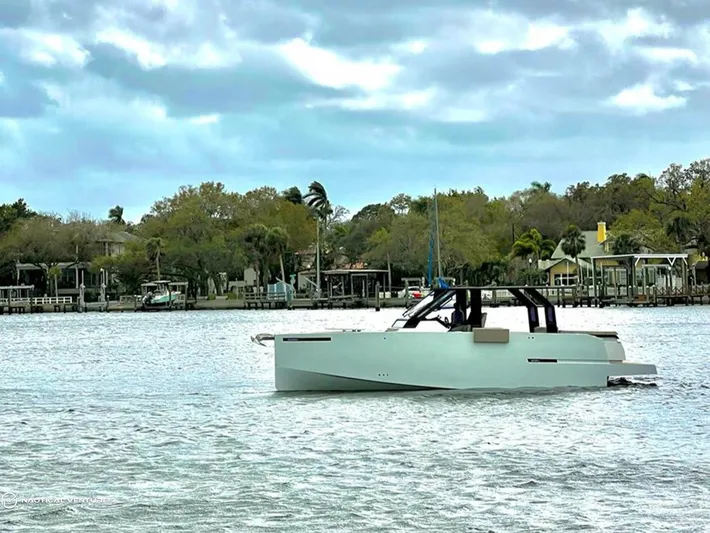  Yacht Photos Pics De Antonio Yachts D34 Xplorer 2022 cruising on a serene lake with a scenic backdrop.